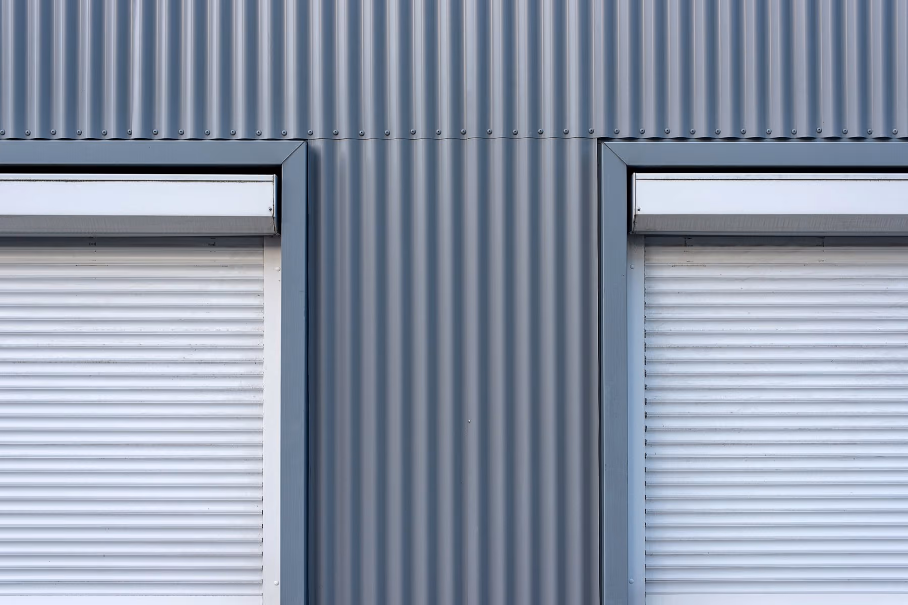 Persianas de aluminio blancas con cajón exterior en una fachada.